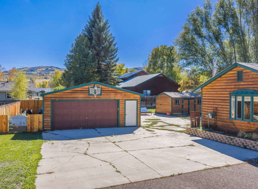 Discover this charming property featuring a spacious two-car garage with a rich wooden exterior and a classic brown garage door.