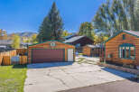 Discover this charming property featuring a spacious two-car garage with a rich wooden exterior and a classic brown garage door.