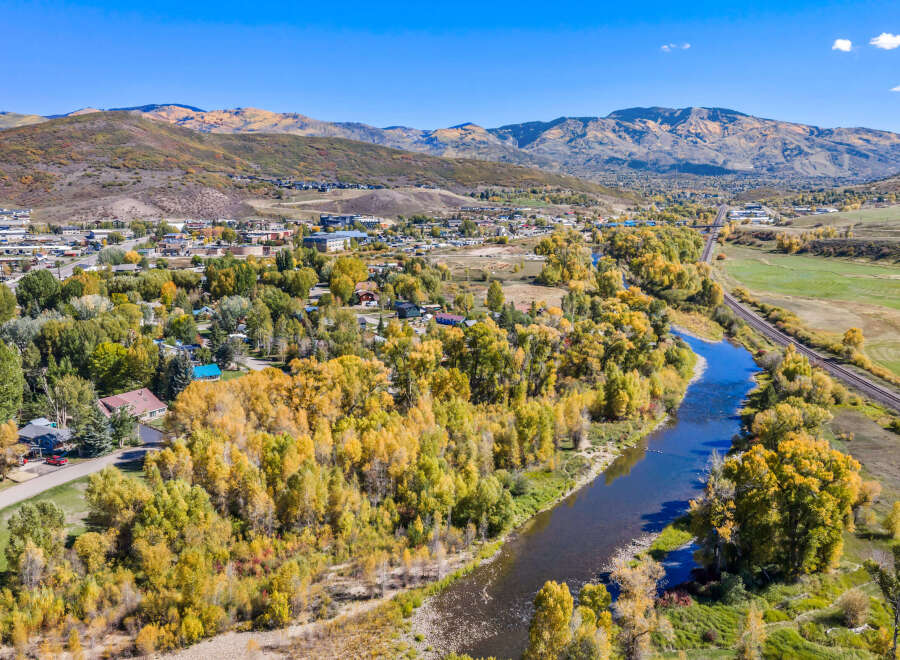 Experience the beauty of autumn in this picturesque mountain town, nestled beside a serene river and surrounded by vibrant fall foliage.