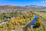 Experience the beauty of autumn in this picturesque mountain town, nestled beside a serene river and surrounded by vibrant fall foliage.