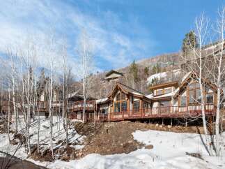 Nestled on a snowy hillside, this multi-level home offers stunning mountain views and a rustic charm.