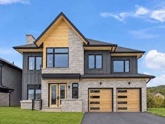 Discover modern luxury in this stunning two-story home, featuring a striking combination of stone and dark siding.