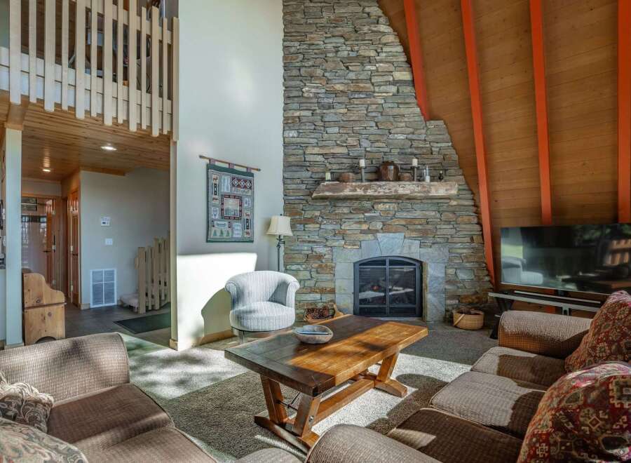 Experience rustic charm in this inviting living room, featuring a grand stone fireplace as the centerpiece.