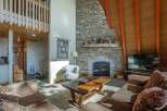 Experience rustic charm in this inviting living room, featuring a grand stone fireplace as the centerpiece.