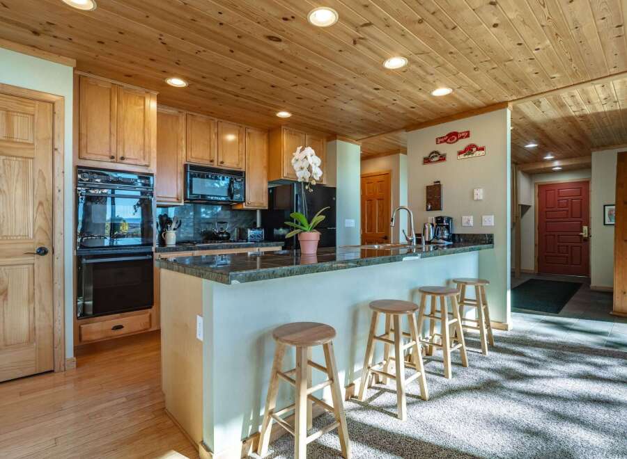 This spacious kitchen boasts beautiful natural wood cabinetry and a coordinating wood-paneled ceiling, creating a warm and inviting atmosphere.