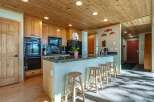 This spacious kitchen boasts beautiful natural wood cabinetry and a coordinating wood-paneled ceiling, creating a warm and inviting atmosphere.