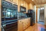 This spacious kitchen features a built-in oven and microwave, complemented by a gas stovetop and a black refrigerator.