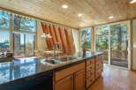 Experience breathtaking mountain views from this stunning kitchen and dining area, featuring a large island with a double sink and ample cabinet space.