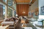 Experience breathtaking mountain views from this stunning living room, featuring a soaring A-frame ceiling and expansive floor-to-ceiling windows.