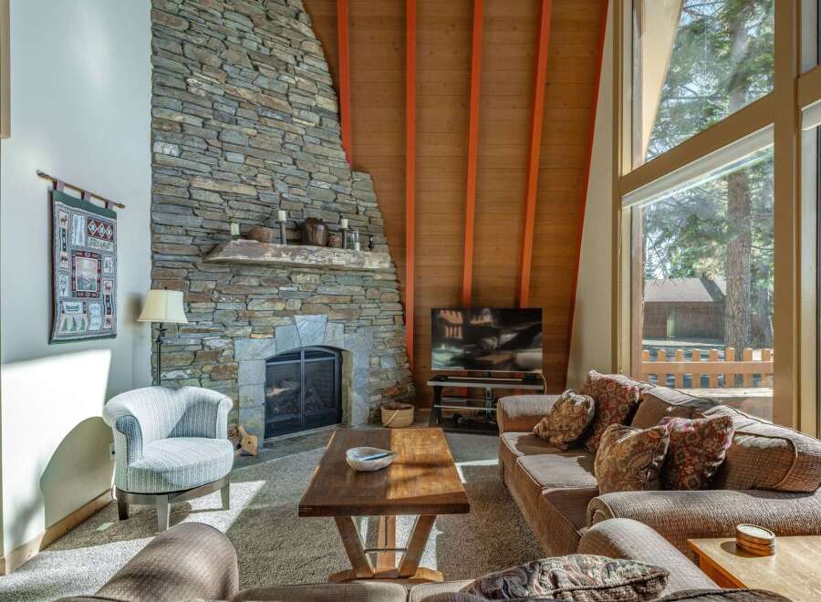 Experience cozy living in this mountain retreat, featuring a stunning floor-to-ceiling stone fireplace perfect for chilly evenings.