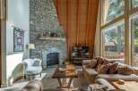 Experience cozy living in this mountain retreat, featuring a stunning floor-to-ceiling stone fireplace perfect for chilly evenings.