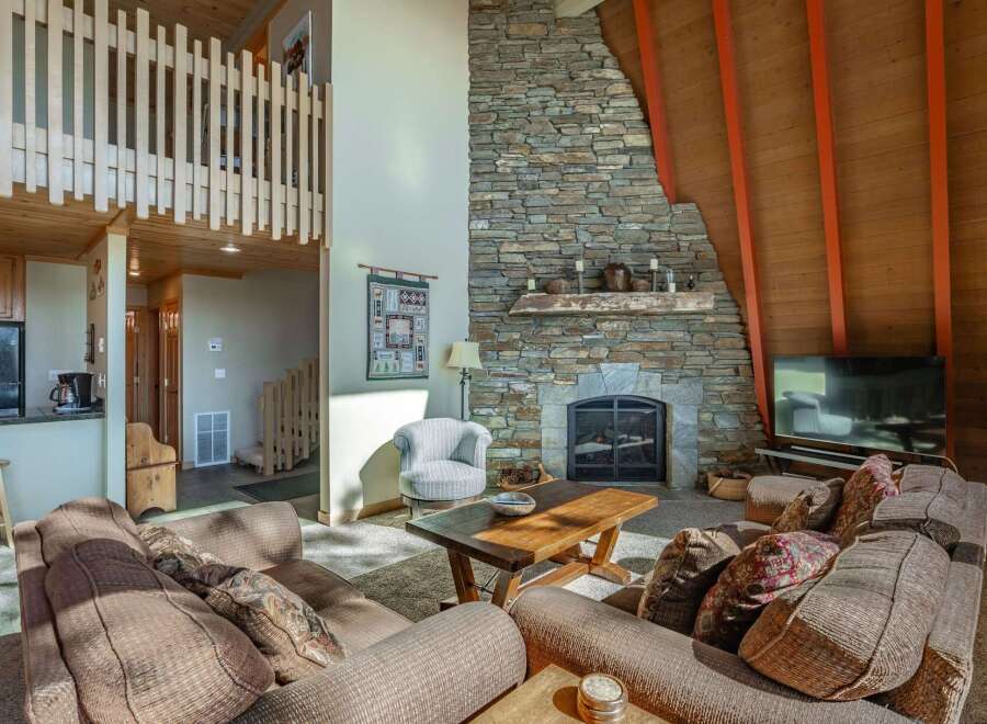 Experience rustic charm in this inviting living room, featuring a grand stone fireplace as the centerpiece.