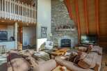 Experience rustic charm in this inviting living room, featuring a grand stone fireplace as the centerpiece.