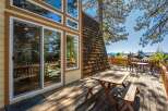 Enjoy the outdoors on this spacious wooden deck, featuring a picnic table and a separate dining set perfect for al fresco meals.