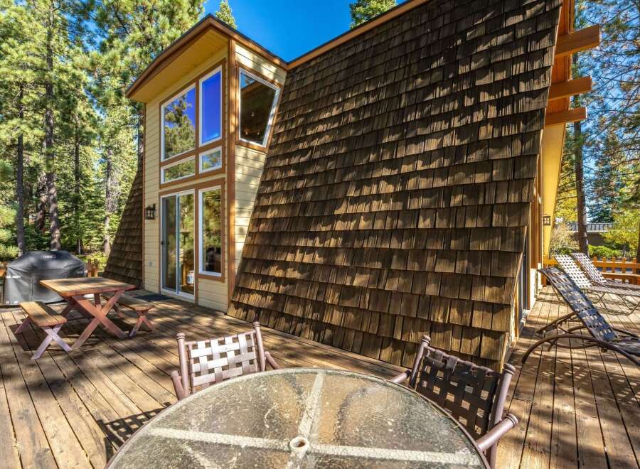 Enjoy outdoor living on this expansive wooden deck, perfect for entertaining or relaxing amidst the serene forest surroundings.