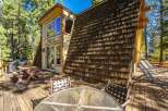 Enjoy outdoor living on this expansive wooden deck, perfect for entertaining or relaxing amidst the serene forest surroundings.