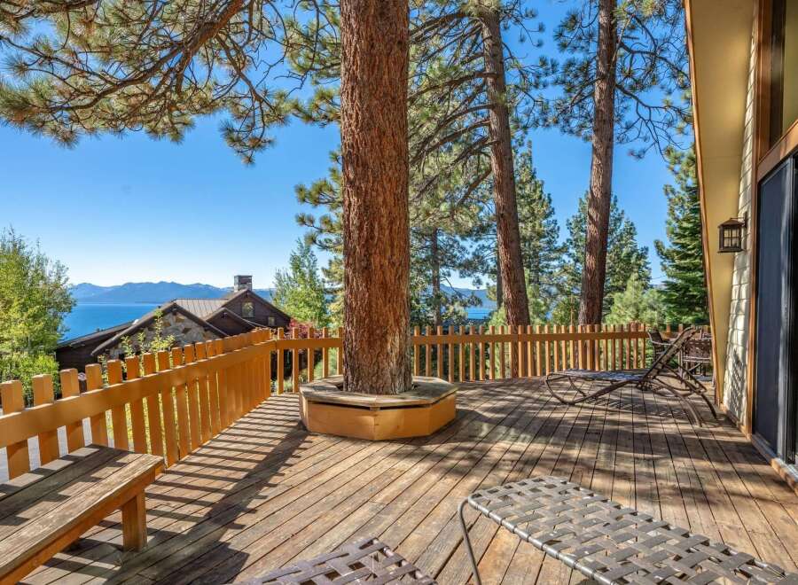 Enjoy breathtaking lake and mountain views from this expansive wooden deck, perfect for entertaining or relaxing.