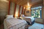 Discover cozy comfort in this charming bedroom featuring two twin beds, perfect for guests or family.