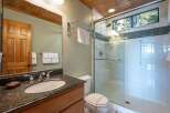 This bathroom features a spacious walk-in shower with a glass door and a rainfall showerhead, perfect for a relaxing experience.