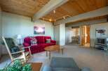 Step into this cozy living room featuring a plush red sofa adorned with decorative pillows and a rustic throw blanket.