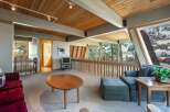 Experience breathtaking lake and mountain views from this stunning living area, featuring a vaulted wood-beamed ceiling and expansive windows.