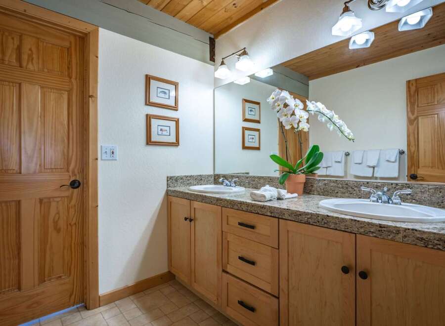 This charming bathroom features a double vanity with granite countertops and ample storage.