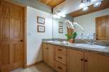 This charming bathroom features a double vanity with granite countertops and ample storage.