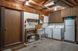 This basement laundry area features a large utility sink, a washing machine, and a dryer, perfect for handling household chores.