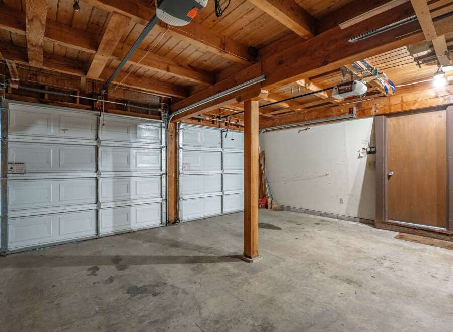This spacious garage offers ample parking with two large overhead doors, perfect for accommodating multiple vehicles.