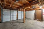 This spacious garage offers ample parking with two large overhead doors, perfect for accommodating multiple vehicles.