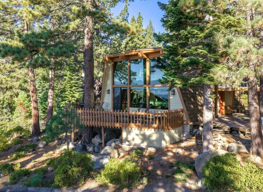 Nestled amidst towering pine trees, this A-frame home offers a unique architectural design with expansive windows that flood the interior with natural light.
