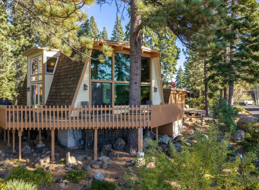 Nestled amidst towering pine trees, this unique A-frame home offers a captivating blend of rustic charm and modern living.