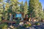 Nestled amongst towering pine trees, this A-frame home offers stunning lake views through its expansive floor-to-ceiling windows.