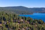 Experience luxury living nestled amidst the towering pines with breathtaking views of a pristine blue lake.