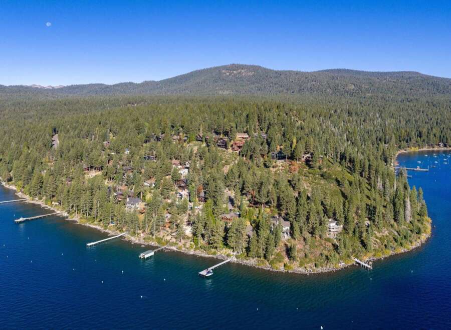 Experience luxury living in this stunning lakeside estate, nestled amidst a dense forest of evergreen trees.