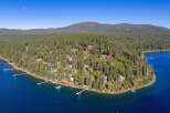 Experience luxury living in this stunning lakeside estate, nestled amidst a dense forest of evergreen trees.
