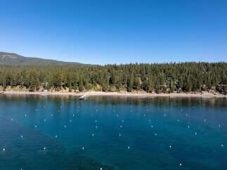 Experience the ultimate lakeside living with this stunning aerial view of a serene lakefront property.