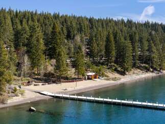 Enjoy the serene beauty of this lakeside property, featuring a pristine sandy beach perfect for relaxation and recreation.