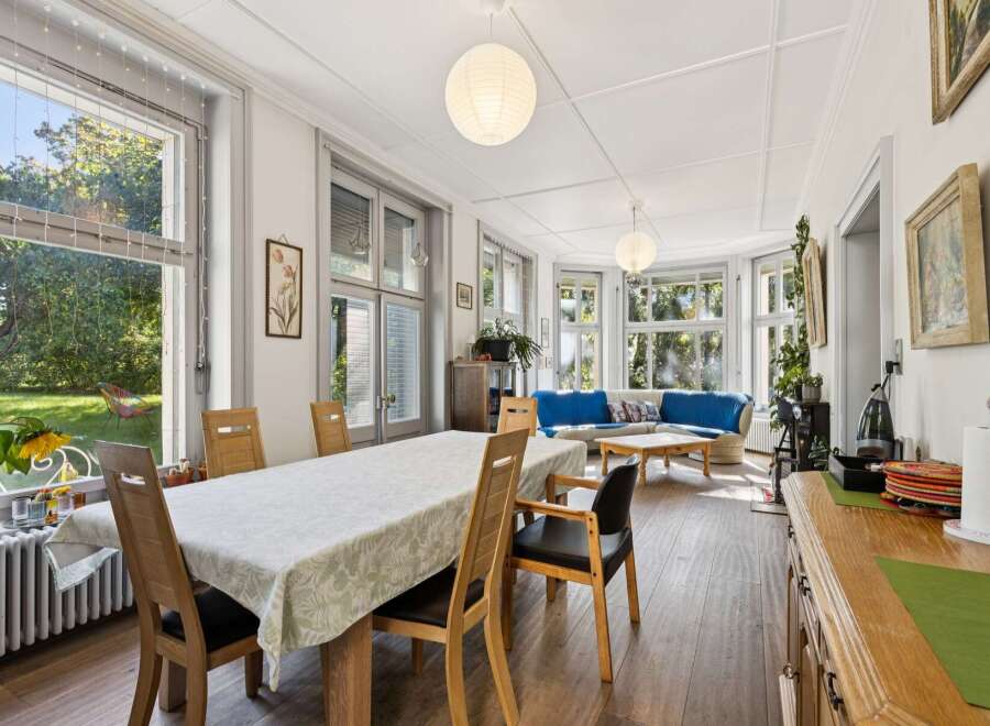 This spacious living and dining area boasts abundant natural light streaming through large windows, creating a bright and airy atmosphere.