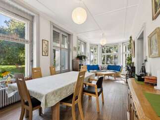 This spacious living and dining area boasts abundant natural light streaming through large windows, creating a bright and airy atmosphere.