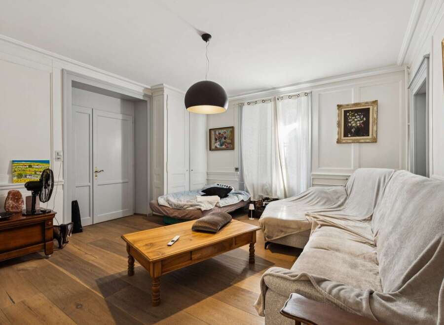 This living room features a comfortable sectional sofa draped with a light-colored throw, perfect for relaxing.