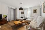 This living room features a comfortable sectional sofa draped with a light-colored throw, perfect for relaxing.