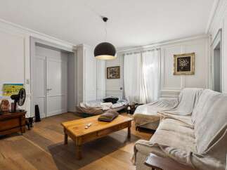 This living room features a comfortable sectional sofa draped with a light-colored throw, perfect for relaxing.