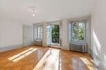 Bathed in natural light, this charming room features a beautifully patterned hardwood floor that catches the sun's rays.