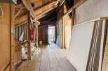 This unfinished attic space offers a blank canvas for renovation, featuring exposed wooden beams and a rustic charm.