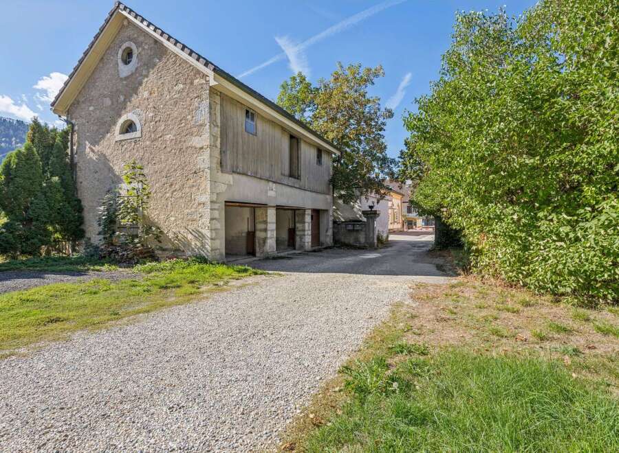 Discover this charming property featuring a rustic stone building with traditional wooden accents and arched windows.