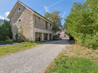 Discover this charming property featuring a rustic stone building with traditional wooden accents and arched windows.