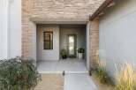 Welcome guests to this modern home with a striking stone facade and a welcoming covered entryway.