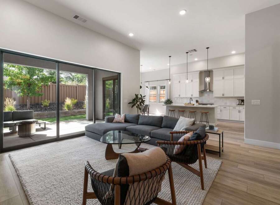 Experience seamless indoor-outdoor living in this modern home, featuring a spacious open-concept living area that flows directly into a beautifully landscaped backyard.