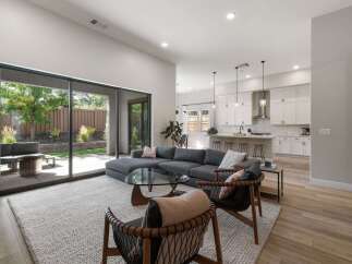 Experience seamless indoor-outdoor living in this modern home, featuring a spacious open-concept living area that flows directly into a beautifully landscaped backyard.